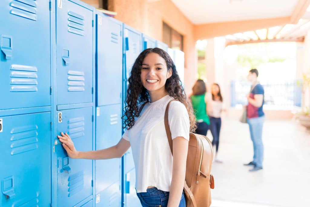 teen in a school hallway in front of the lockers