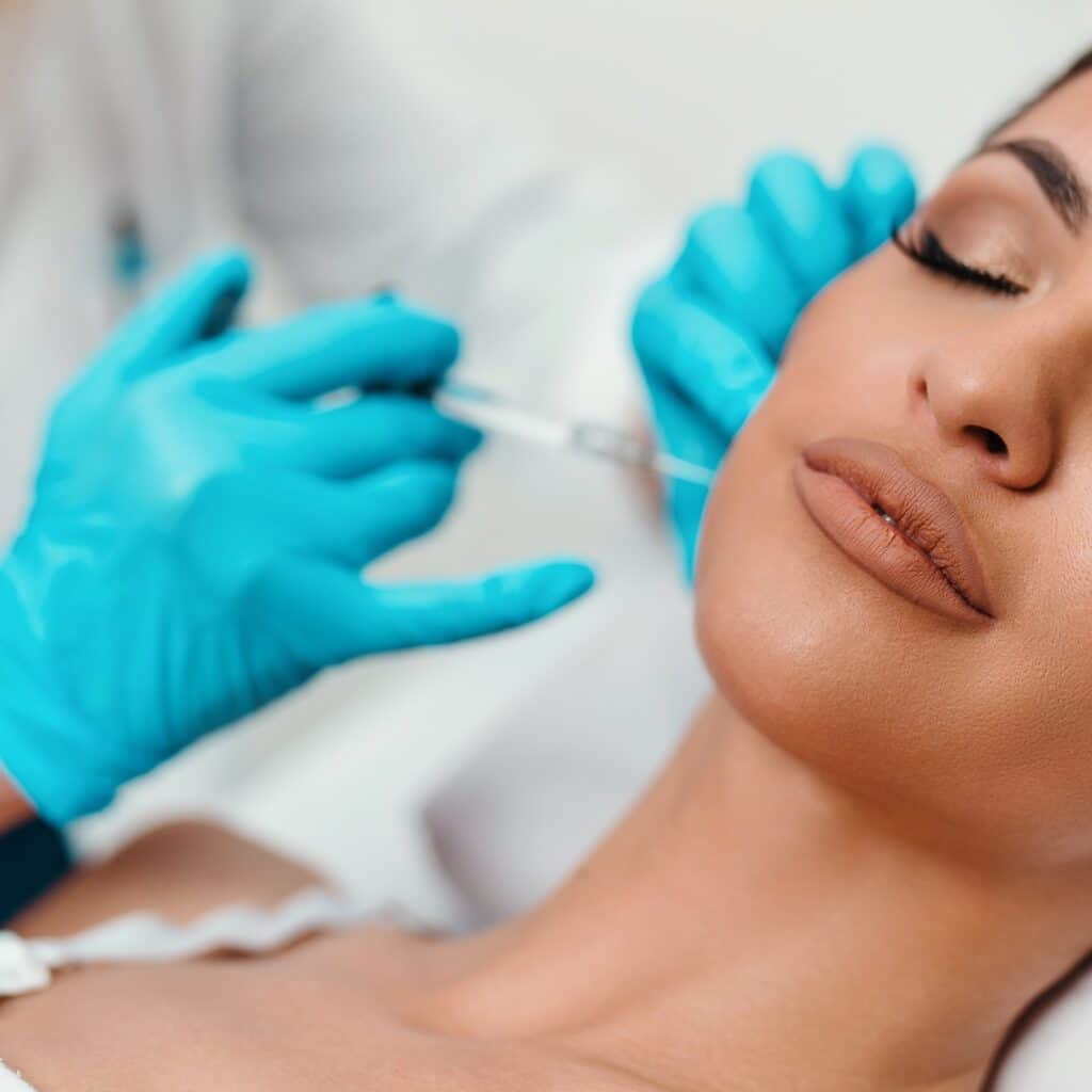 Beautician Is Contouring The Woman'S Cheekbones With Hyaluronic Acid Filler. Hyaluronic Acid Filler Is Injected By Needle Or Cannula. Face Contouring Concept.