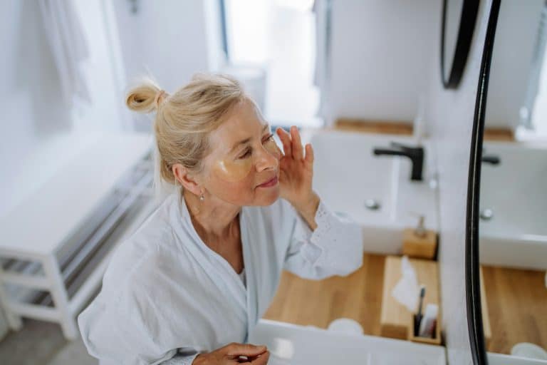 A Photo Of An Older Women Applying Anti-Aging Cremes