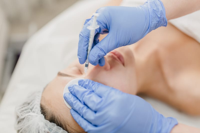 How To Add Medical Aesthetic Services To Your Business 6 Hands In Blue Glows Of Cosmetologist At Work With Pretty Woman During Injection On Face. Rejuvenation, Professional, Healthcare, Medicine, Medical Therapy, Skincare, Botox