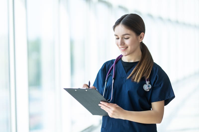 Smiling Young Female Doctor Holding Clipboard Hospital