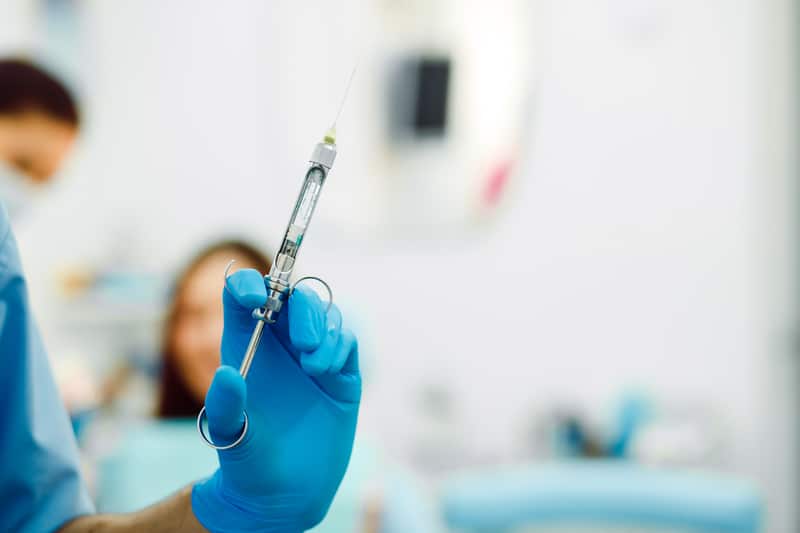 Close-Up Dentist Hands With Glove Syringe