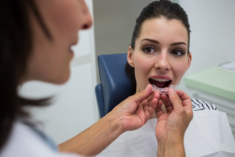 Dentist Fitting Clear Mouth Guard For Patient To Help Protect Teeth From Grinding And Bruxism Damage