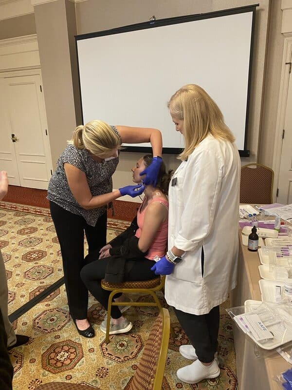 Medical Professional Performing A Supervised Jaw-Area Injection During Hands-On Aafe Tmj Training.
